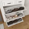 A white shoe cabinet with multiple shelves displaying various shoes. Produktbild-Vorschau