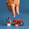 A child's hand is about to interact with a LEGO Stuntz Skorpion-Stuntbike set, which includes a motorcycle and a minifigure. Náhled obrázku produktu