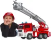 A young boy wearing a red helmet lies next to a toy fire engine with a ladder. Náhled obrázku produktu