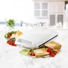 A white sandwich maker is displayed on a marble countertop, surrounded by toasted sandwiches and cherry tomatoes. Produktbild-Vorschau