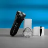 A black electric shaver and its accessories are displayed on a gray surface with a blue background. Voir les images du produit
