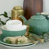A tea set with sandwiches and a decorative wooden object. Produktbild-Vorschau