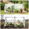 Two mini greenhouses are shown, one with potted plants and flowers, and the other with vegetables planted directly in the soil. Produktbild-Vorschau