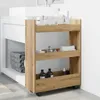 A narrow, three-tiered storage cart with an artisan oak finish, positioned next to a bathroom vanity with a white sink. Voir les images du produit