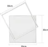 A white square LED ceiling light with a white frame, shown with dimensions indicated by text. Voir les images du produit