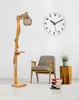 A floor lamp with a wooden base and a rope-wrapped pole, next to a chair and a stack of books. Anteprima dell’immagine prodotto