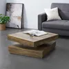 A modern living room scene featuring a square coffee table with a book and glass on it, a sofa with a pillow, and a potted plant next to a framed artwork. Produktbild-Vorschau