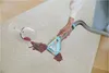 A person is using a portable carpet cleaner to remove a red wine stain from a cream-colored rug. A wine glass has tipped over, spilling the wine. Podgląd zdjęcia produktu