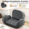 A gray floor chair with adjustable backrest and armrests is shown in a room with soft lighting. Produktbild-Vorschau