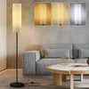 A modern living room with a gray sofa, a wooden coffee table, and a tall, slender floor lamp. Náhľad obrázku produktu