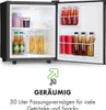 An open mini-fridge filled with drinks and jars, with marketing text and an icon below. Produktbild-Vorschau