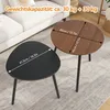 Two coffee tables, one black and one brown, are shown on a rug in a living room setting with a sofa in the background. Produktbild-Vorschau