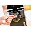 A close-up of a person's hand operating a black appliance. Anteprima dell’immagine prodotto