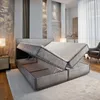 A modern bedroom with a bed that has its storage compartments open. Produktbild-Vorschau