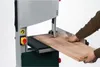 A person is using a bandsaw to cut a piece of wood. Anteprima dell’immagine prodotto