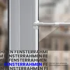 Close-up of a white curtain rod attached to a window frame, with overlaid text. Voir les images du produit