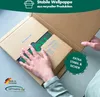 A person's hands are shown packing a product into a cardboard box. Produktbild-Vorschau