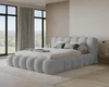 A modern bedroom with a large, upholstered bed. Produktbild-Vorschau