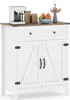 A white sideboard cabinet with a wooden top, featuring two cabinet doors with barn door style detailing and a single drawer. It is decorated with a coffee maker, bags of coffee, a bowl of fruit, and a vase with flowers. Produktbild-Vorschau