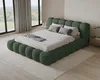A bedroom with a green upholstered bed, large windows with curtains, and a rug. Voir les images du produit