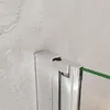 A close-up view of a shower screen hinge and frame against a textured wall. Produktbild-Vorschau