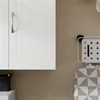 A close-up shot of a white cabinet door and an ironing board hanging on a wall. Náhled obrázku produktu