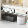 A close-up view of a drawer slide and items stored on a shelf. Voir les images du produit
