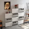 A white shoe cabinet with multiple flip-down drawers is shown in a room. Voir les images du produit