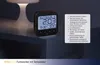 A digital alarm clock with temperature display sits on a nightstand next to a lamp. Anteprima dell’immagine prodotto