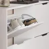 A white shoe cabinet with two pairs of shoes inside. Voir les images du produit
