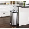 A stainless steel trash can with its lid open, placed next to a kitchen island in a modern kitchen. Anteprima dell’immagine prodotto