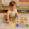 A baby is playing with number cards on the floor. Produktbild-Vorschau