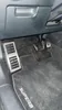 The interior of a car, focusing on the driver's footwell with pedals and floor mats. Produktbild-Vorschau