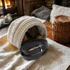 A black leather belt and wallet are placed on a textured beige cloth in front of a fireplace. Anteprima dell’immagine prodotto