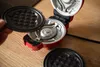 A person is holding a waffle plate from a mini waffle maker, with the waffle maker open and another plate visible. Produktbild-Vorschau