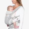 A woman is wearing a baby carrier with a baby inside. Podgląd zdjęcia produktu