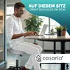 A man works on a laptop while sitting on a rolling stool in an office. Anteprima dell’immagine prodotto