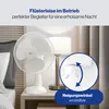 A white desk fan is shown on a bedside table next to a lamp and curtains, with a close-up inset highlighting its adjustable tilt function. Produktbild-Vorschau