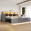 A modern bedroom with a sofa bed extended into a bed, featuring a headboard with integrated shelving and lighting. Voir les images du produit