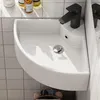 A white corner sink with a black faucet is mounted on a tiled wall. Anteprima dell’immagine prodotto