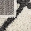 A close-up view of a rug with a diamond pattern. Produktbild-Vorschau