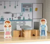 A wooden dollhouse kitchen scene with two child figures, a table, and chairs. Produktbild-Vorschau
