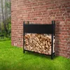 A metal firewood rack filled with logs is placed next to a brick wall in a grassy yard. Produktbild-Vorschau