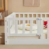 A close-up view of a white wooden crib with a mattress and two decorative pillows inside. A red owl plush toy is visible in the background. Náhľad obrázku produktu