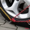 A close-up shot of a car tire with snow chains attached. Produktbild-Vorschau