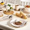 A dining table setting with plates, cutlery, cups, and food. Produktbild-Vorschau
