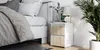 A bedside table next to a bed in a bedroom setting. Produktbild-Vorschau