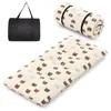 A black carrying bag and a rolled-up and unrolled mattress with a bear pattern are displayed against a white background. Produktbild-Vorschau