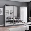 A modern living room with a large gray wardrobe with mirrored doors, a gray sectional sofa, and coffee tables. Náhľad obrázku produktu