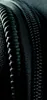 A close-up abstract view of a black zipper and textured fabric. Náhľad obrázku produktu